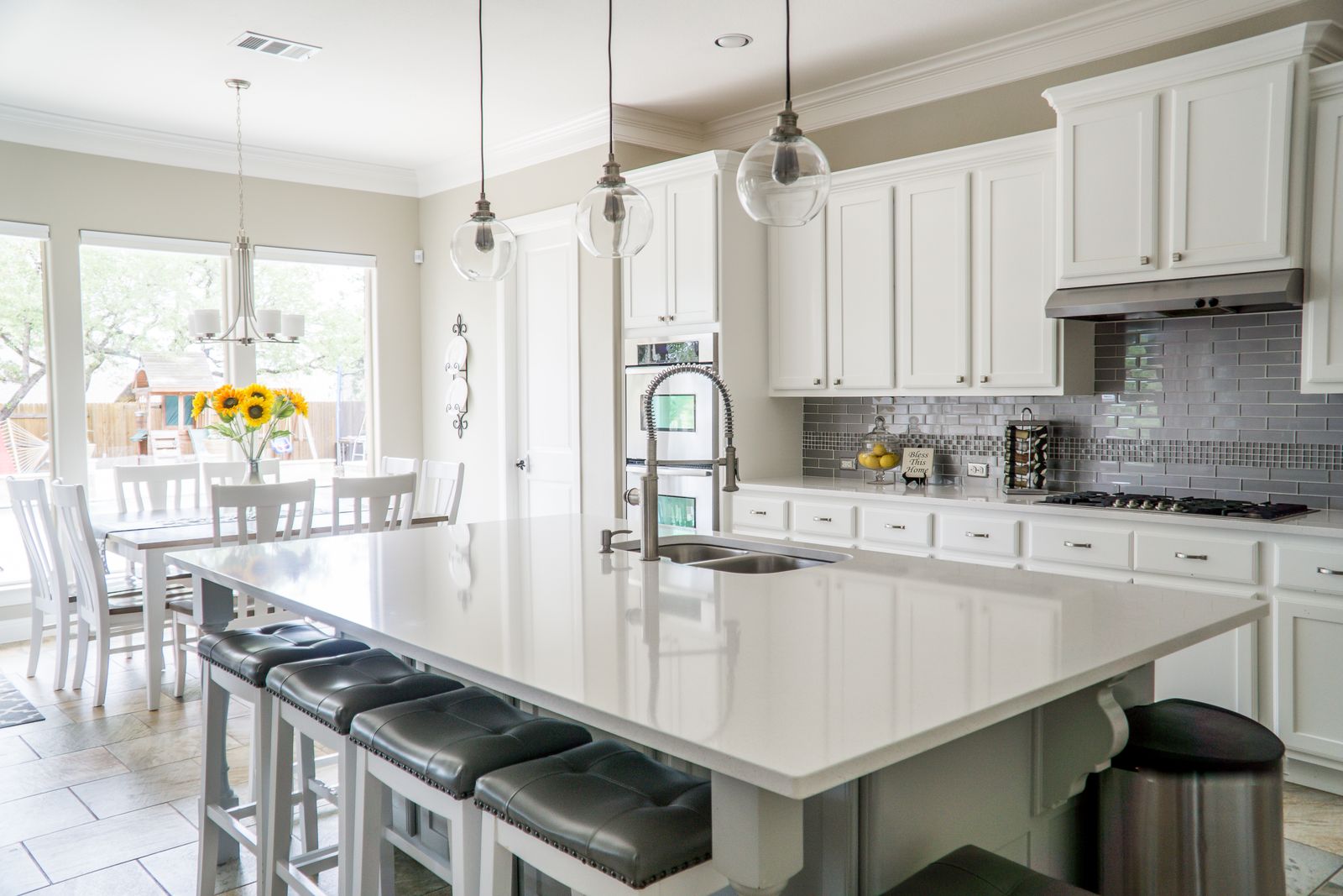 White remodeled kitchen with an island and stone countertops