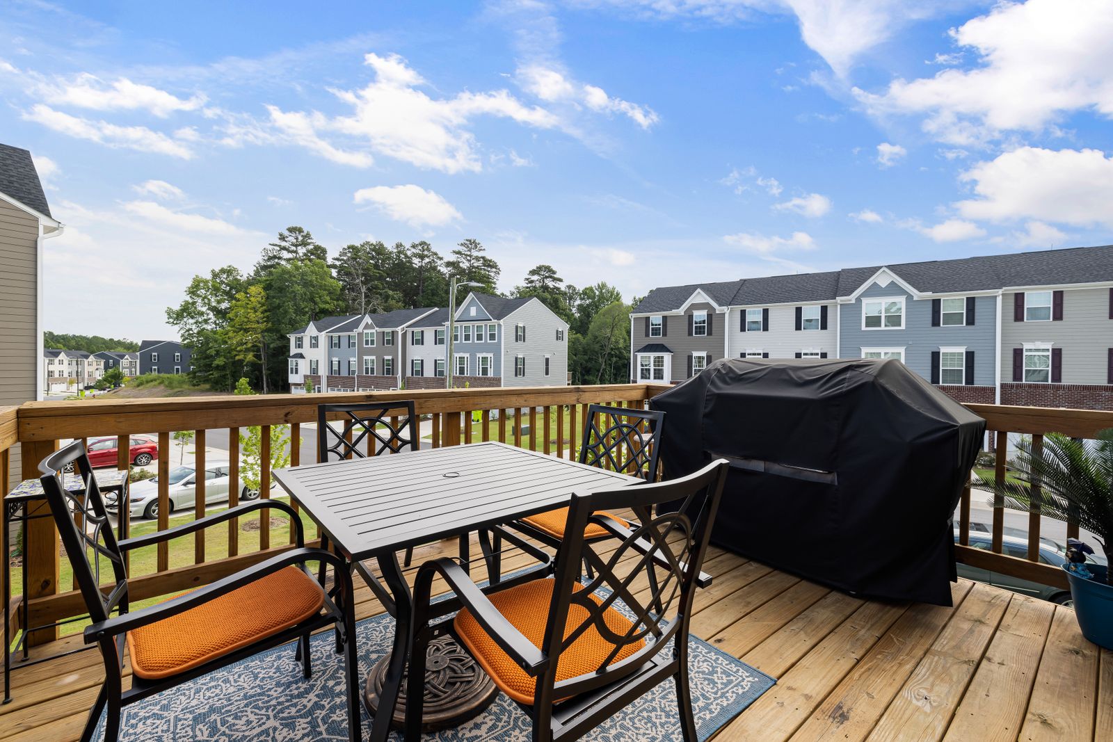 Wooden backyard deck with outdoor furniture and railing